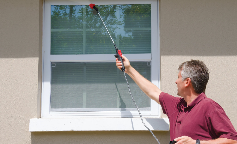 man spraying window insect control
